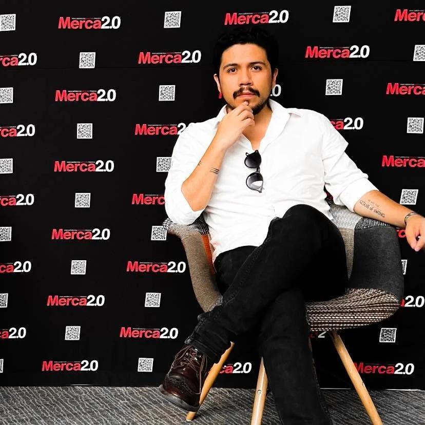 Alexis Soubran seated in front of the Merca2.0 congress backdrop