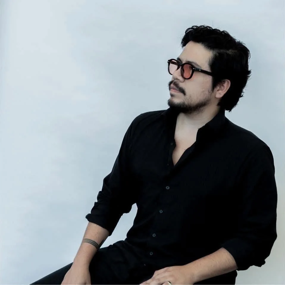 Alexis Soubran seated in a black shirt and glasses